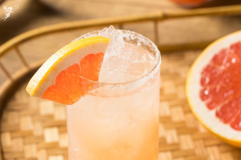 a close up of the grapefruit slice hanging on a highball glass of grapefruit drink alcohol free paloma recipe