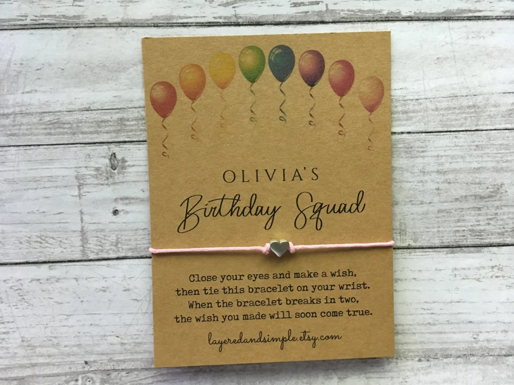 Personalized kraft card birthday wish bracelet with a pink cord and silver heart charm, a sweet and meaningful choice for tween girl party favors.
