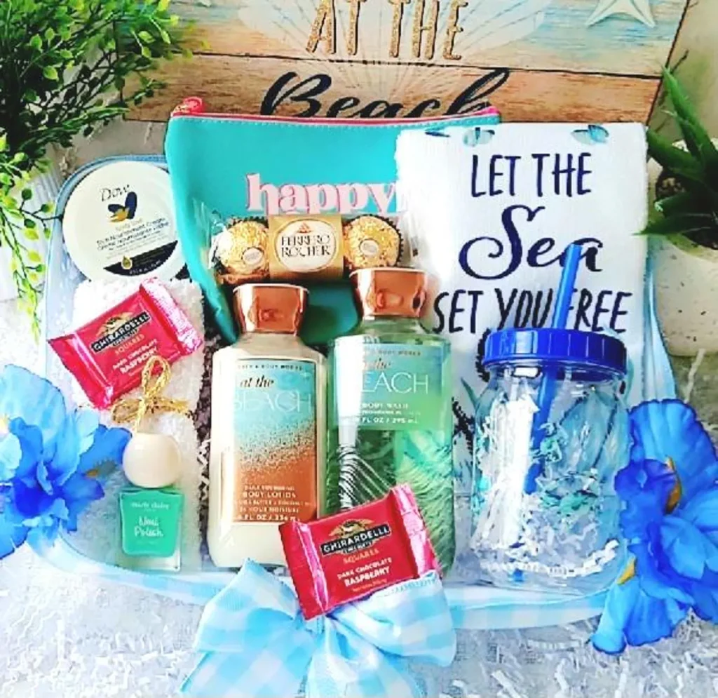 A beach themed self care gift basket filled with body lotion, body wash, nail polish, chocolates, a tumbler and a toiletry bag, a fun and summery July birthday gift idea.