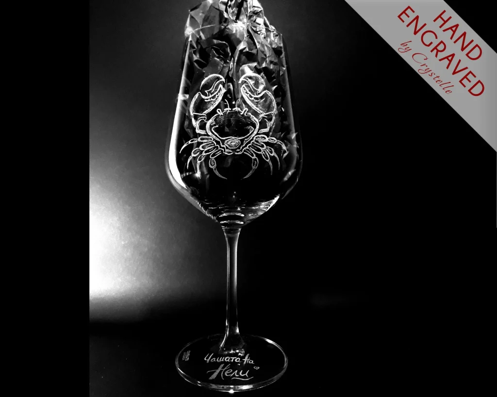 A hand engraved stemmed wine glass featuring a detailed Cancer zodiac crab etching, an elegant and unique July birthday gift idea.