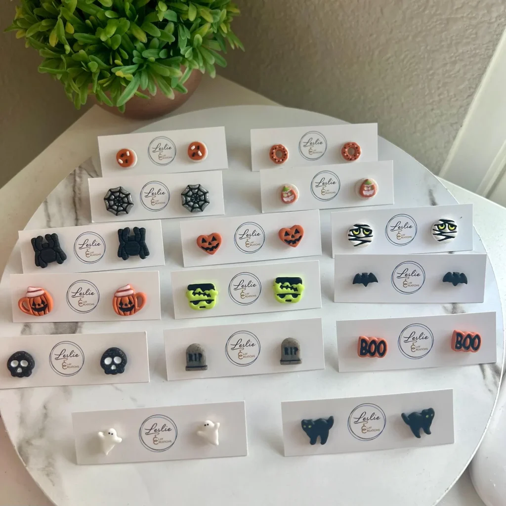 Handmade clay stud earrings with Halloween designs like pumpkins, ghosts, cats, and spiderwebs, adorable Halloween party favors for kids.