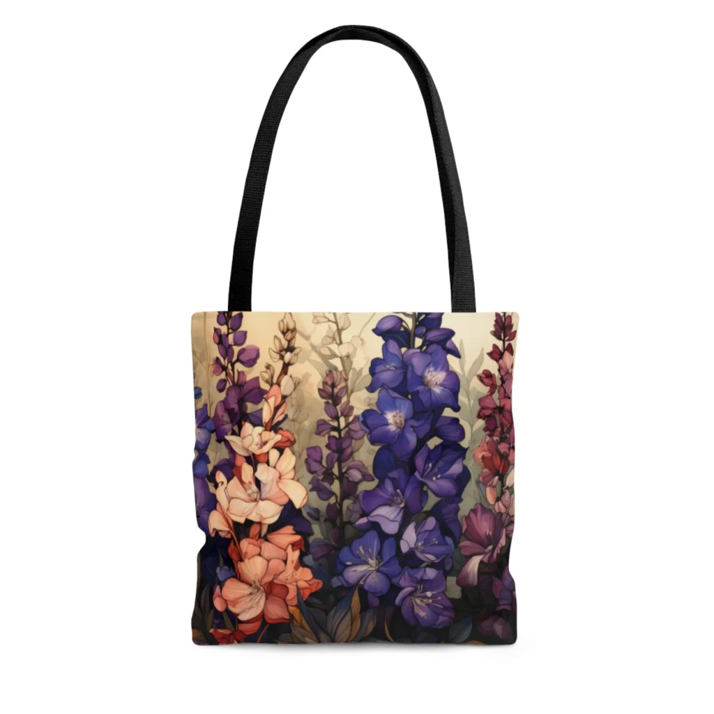 A canvas tote bag printed with a rich botanical illustration of purple, blue and pink larkspur blooms, a stylish and everyday July birthday gift idea.