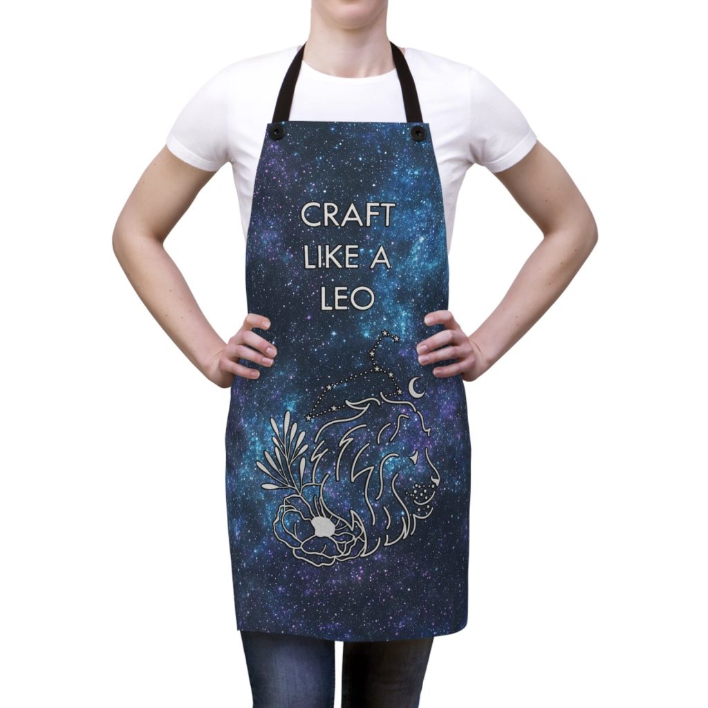 A galaxy print apron featuring a celestial Leo constellation and floral lion illustration, a creative and personalized August birthday gift idea.