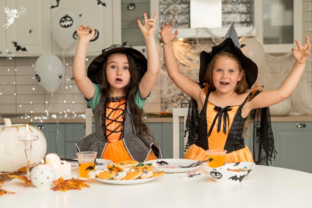 two young girls dressed as witches black and orange party