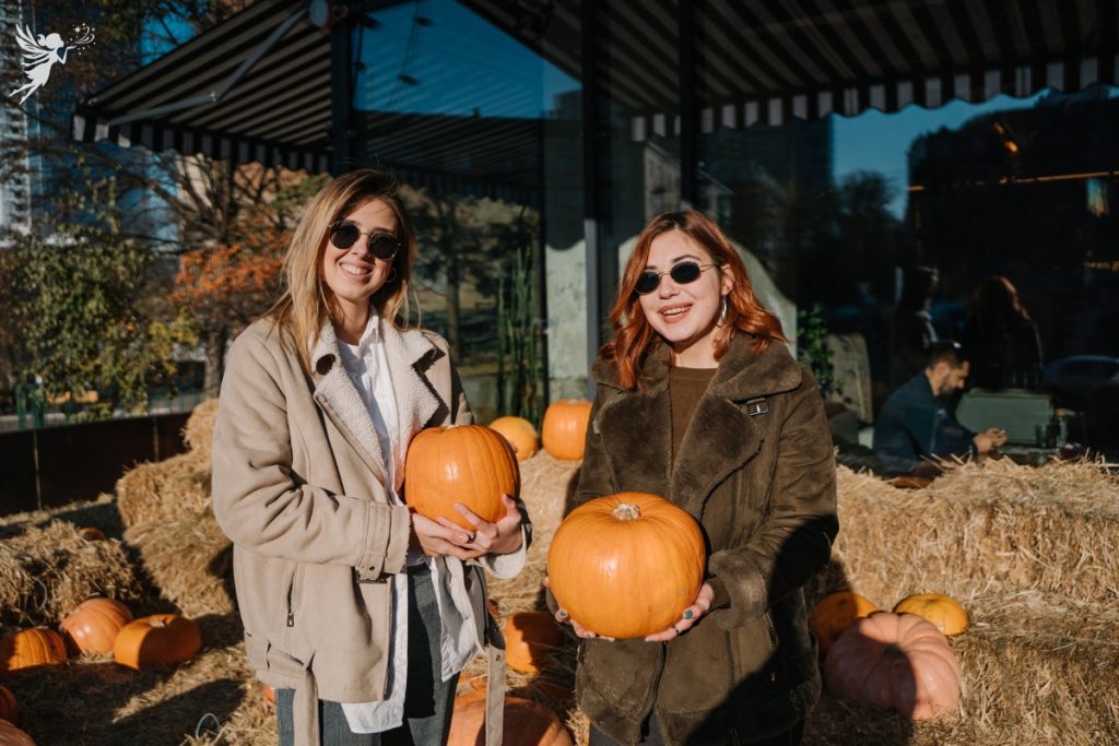 adult female friends enjoying a pumpkin patch event