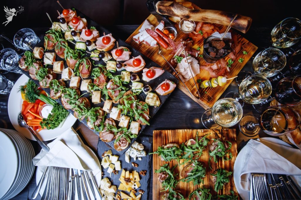 caterinhg buggeft spread overhead view of party food and wine glasses poured