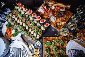 caterinhg buggeft spread overhead view of party food and wine glasses poured