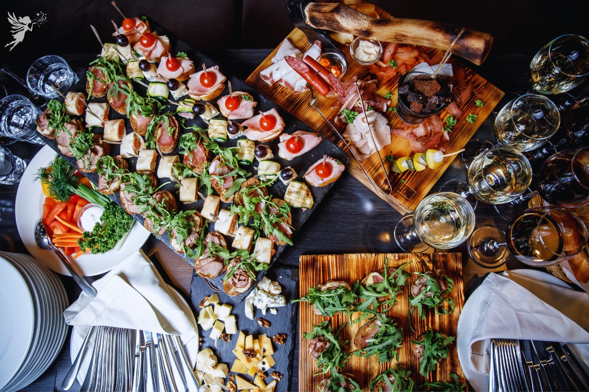 caterinhg buggeft spread overhead view of party food and wine glasses poured