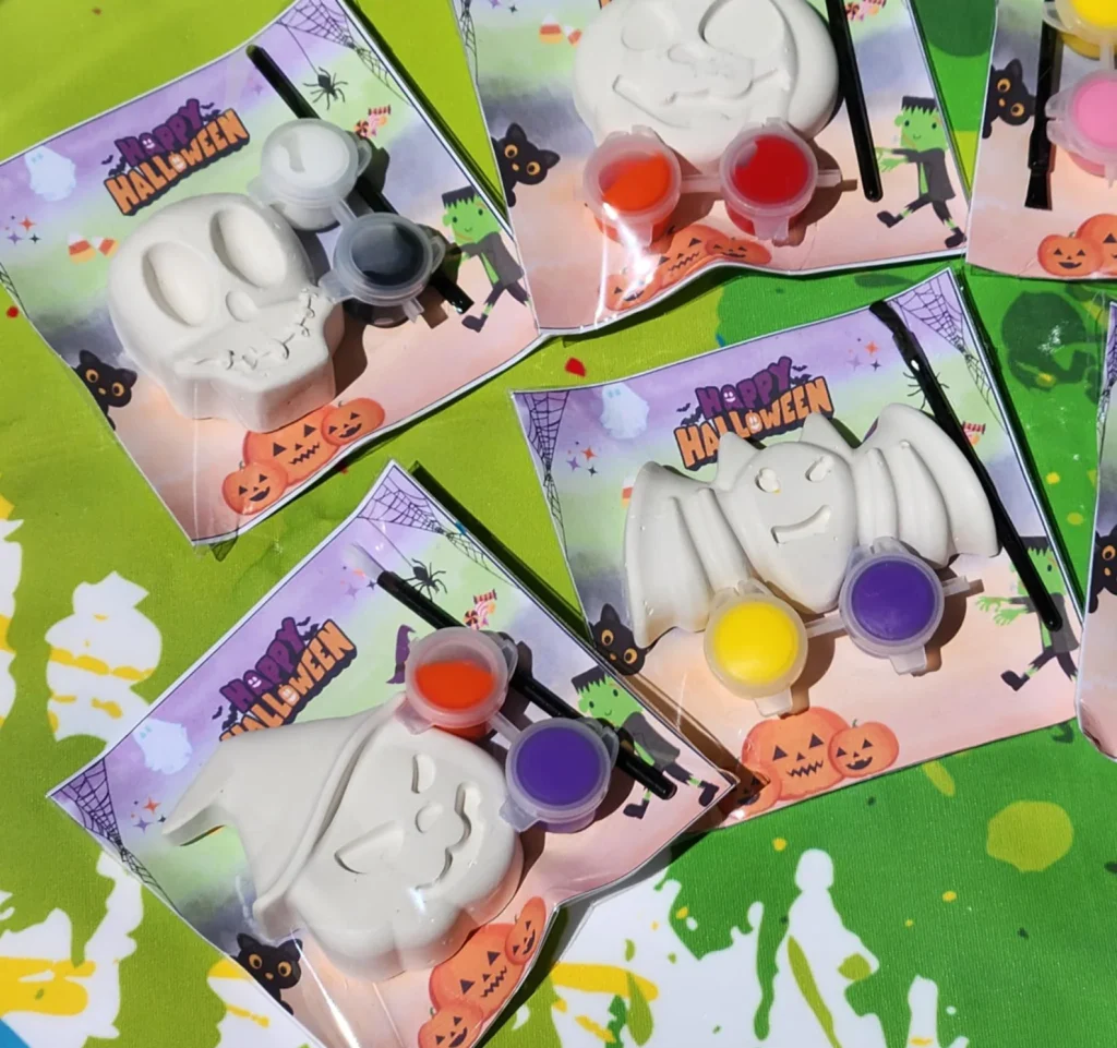 Mini paint-your-own Halloween figurine kits with skull, ghost, and bat shapes plus paint pots, ideal Halloween party favors for kids.