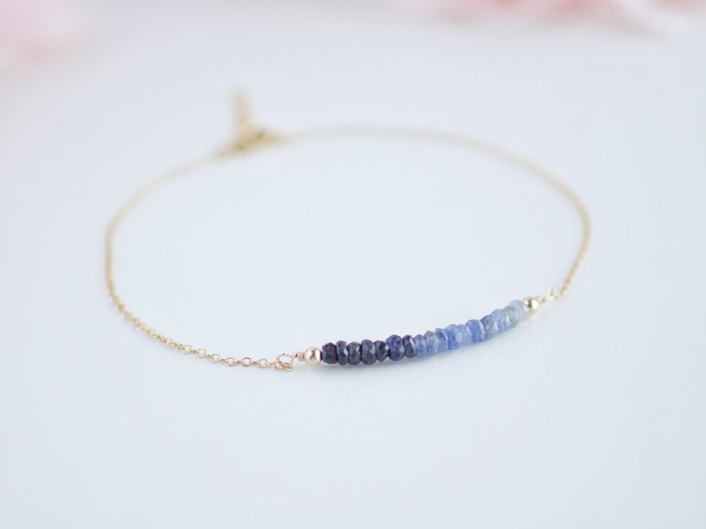 Delicate gold bracelet with an ombre row of blue sapphire beads, a dainty option for September birthday gift ideas.