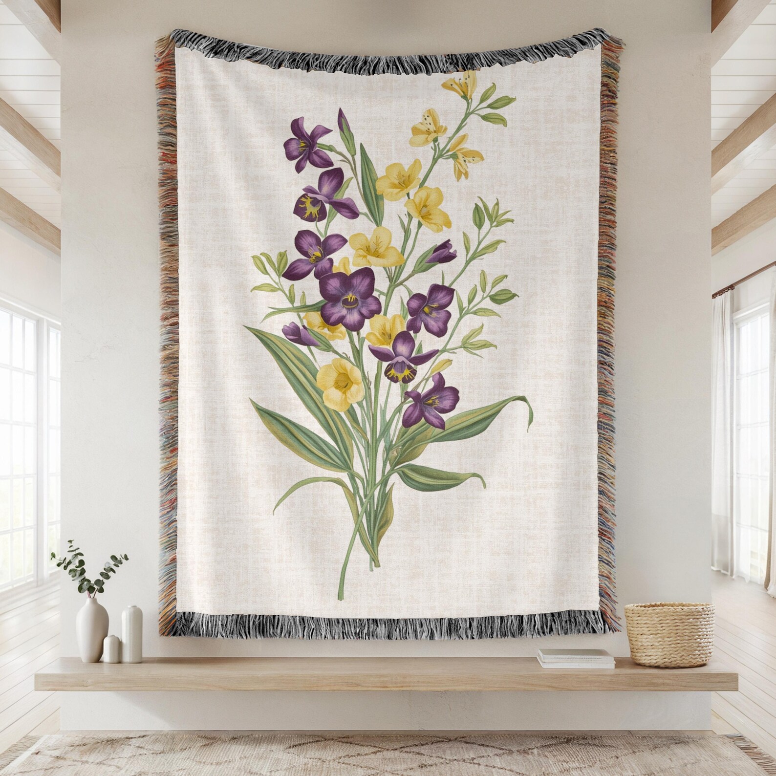 A cream woven fringe throw blanket printed with a vintage botanical bouquet of purple and yellow violet flowers, a cozy and beautiful February birthday gift idea.