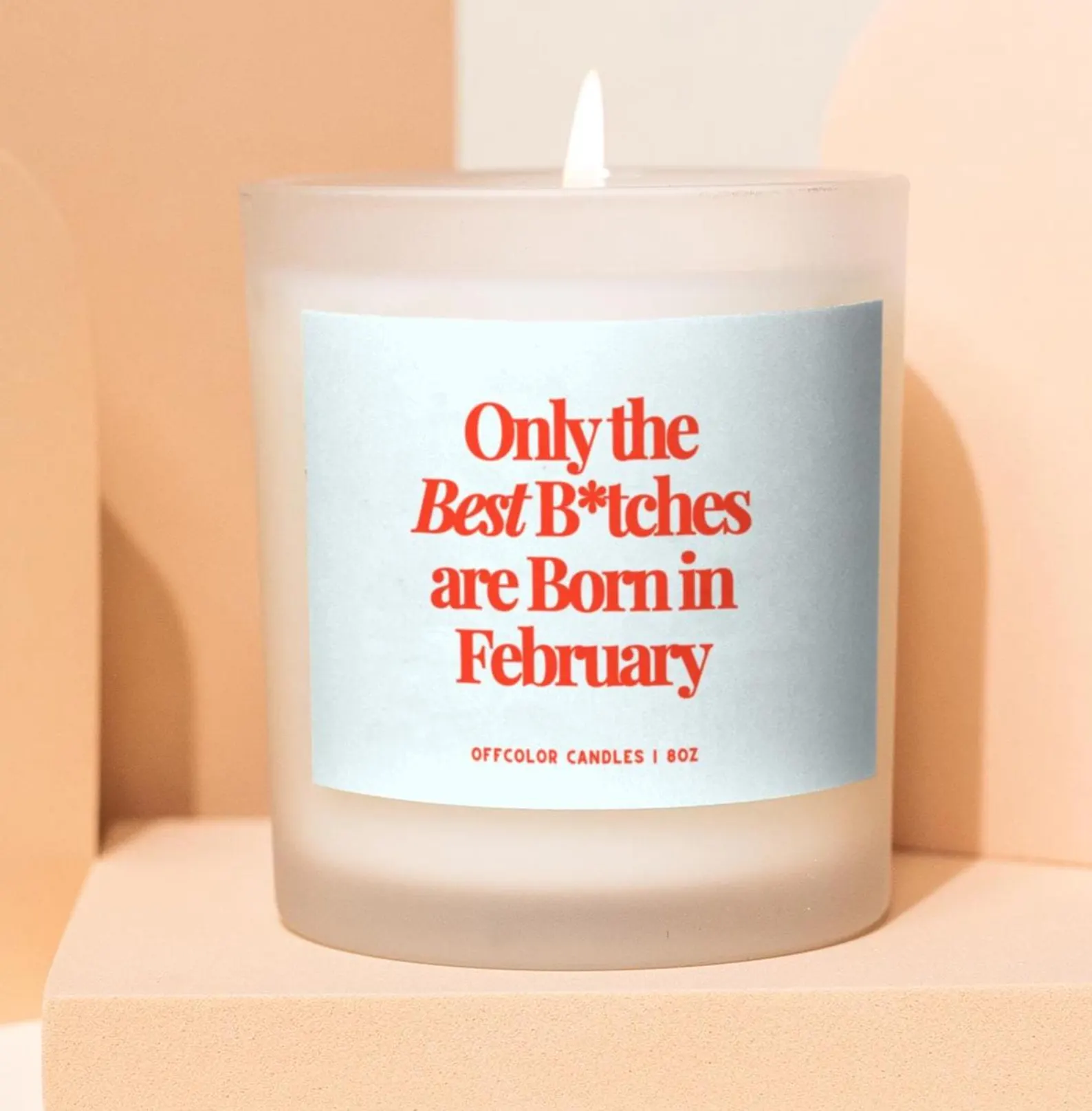 A frosted glass candle with a cheeky bold red humor quote about February birthdays, a funny and lighthearted February birthday gift idea.