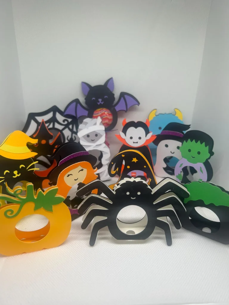 Colorful foam Halloween lollipop holders shaped like bats, spiders, mummies, and monsters, playful Halloween party favors for kids.
