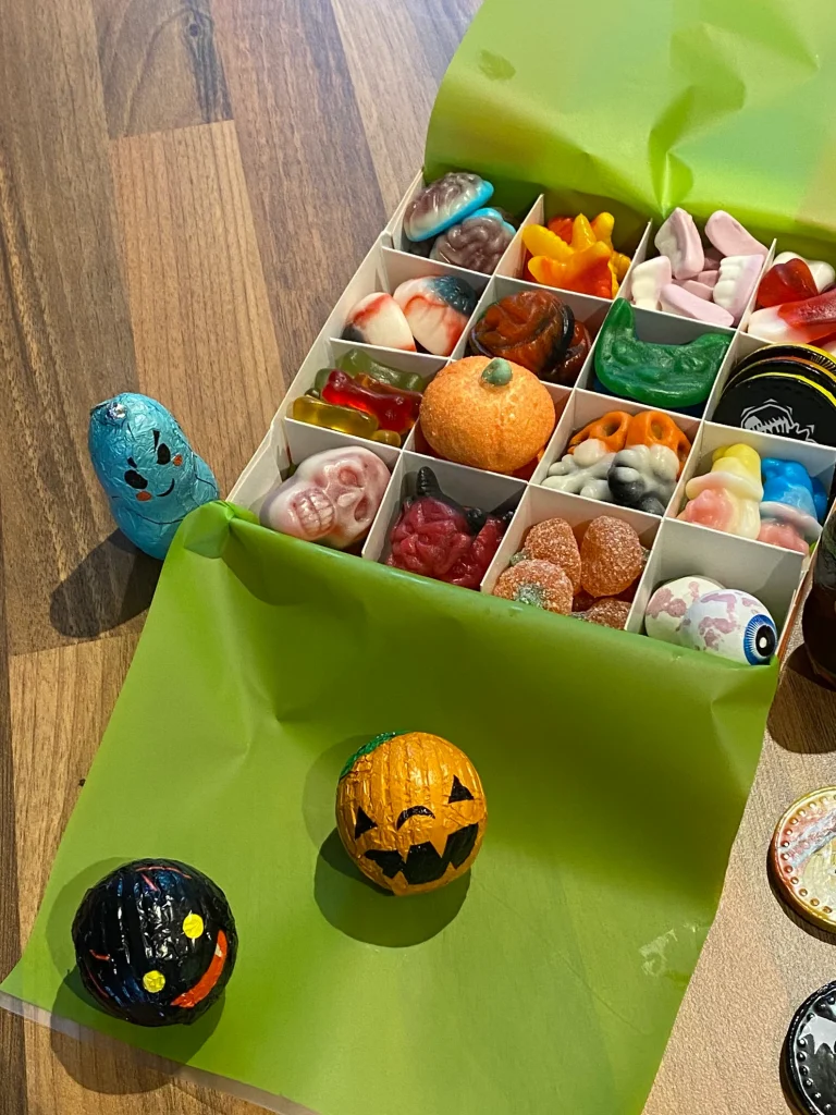 Pick-and-mix Halloween candy box with spooky gummies like skulls, eyeballs, and worms, a fun assortment of Halloween party favors.
