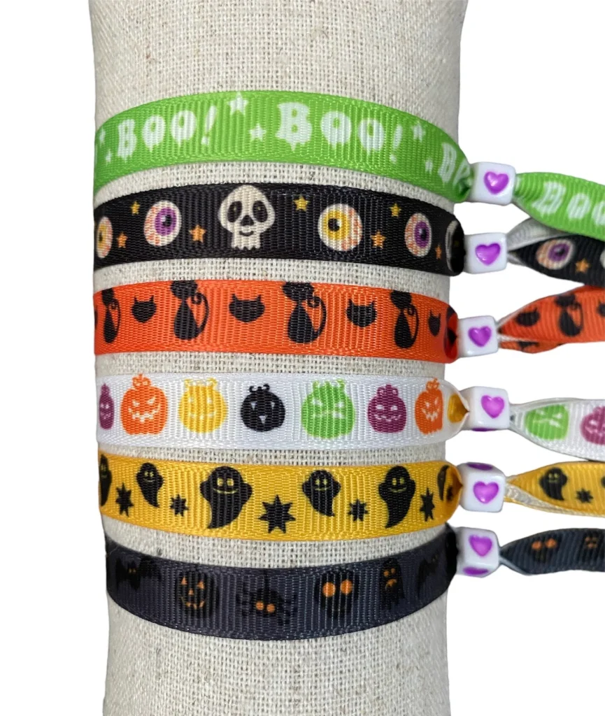Ribbon bracelets with Halloween prints like skulls, ghosts, black cats, and pumpkins, colorful Halloween party favors for kids.