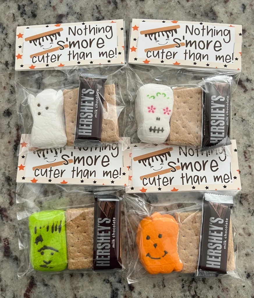 Halloween-themed s'mores kits with decorated marshmallows, graham crackers, and Hershey's chocolate, sweet and fun Halloween party favors.