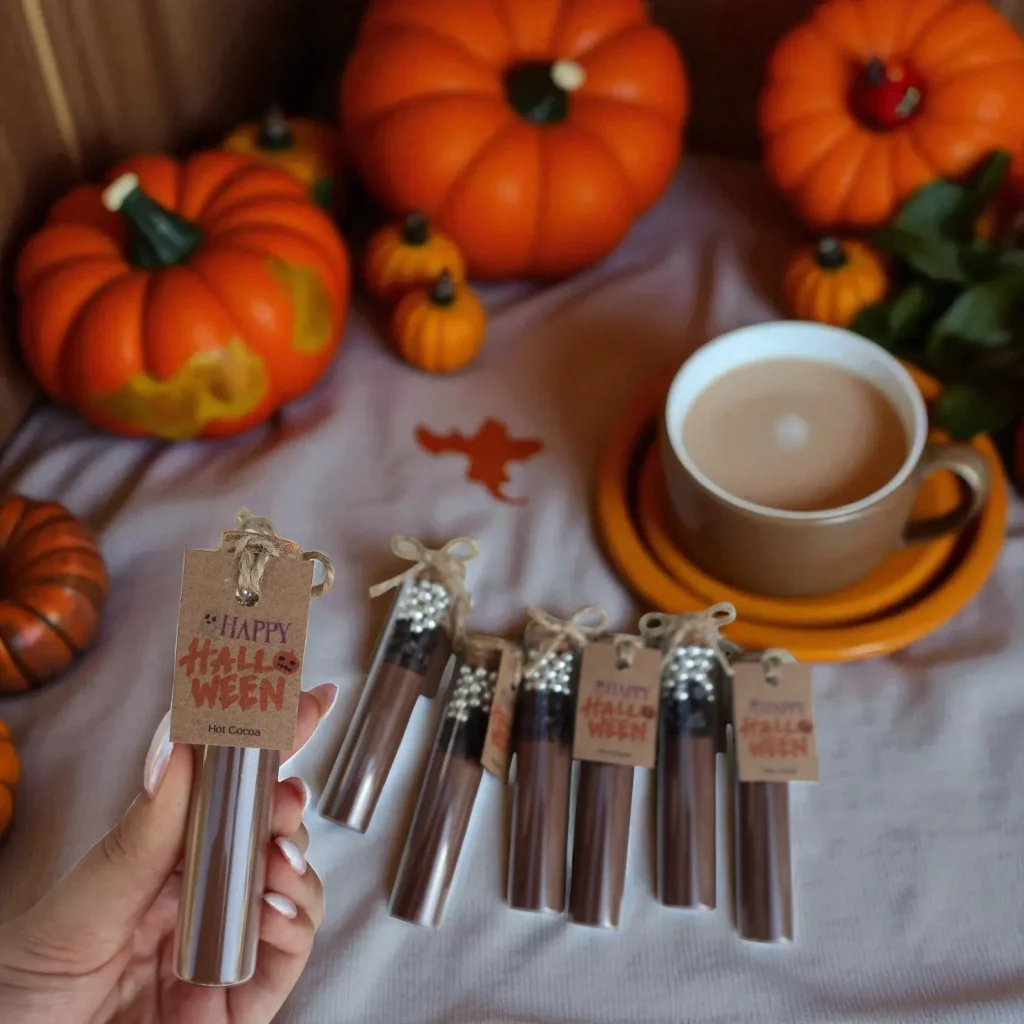 Witches' brew hot cocoa tubes tied with twine and "Happy Halloween" tags, a cozy autumn treat for Halloween party favors.