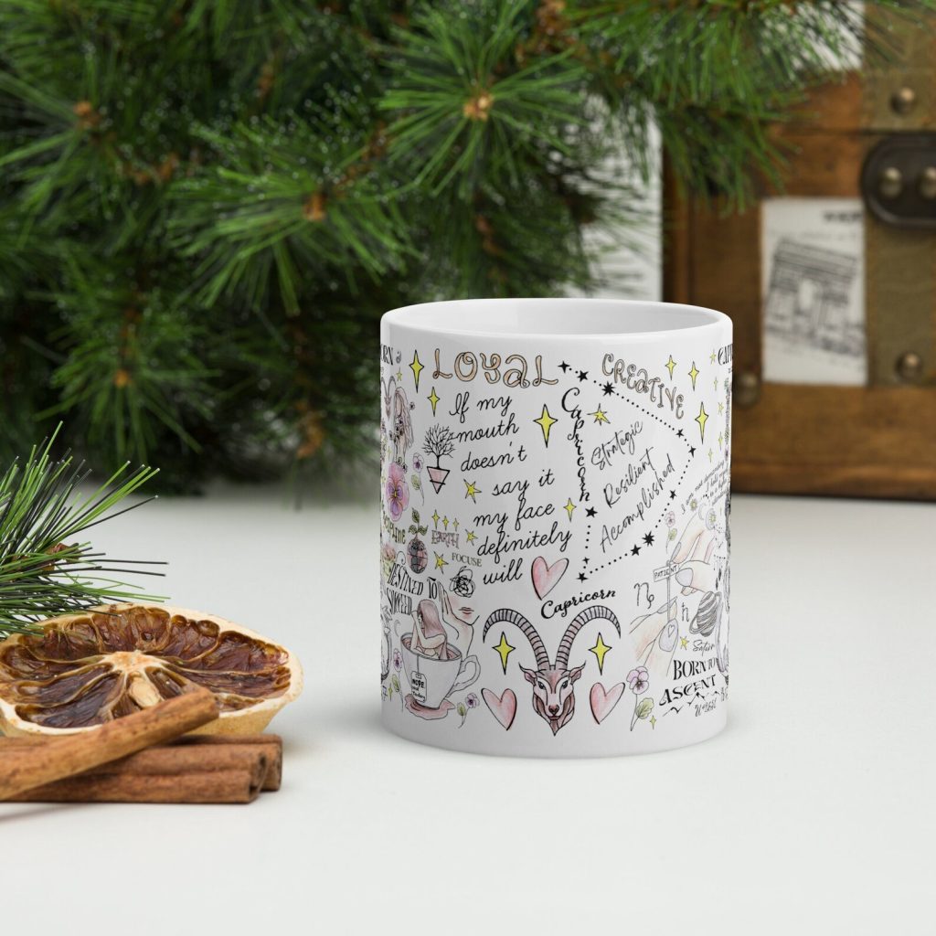 A white Capricorn coffee mug covered in zodiac traits and illustrations, a charming and personalized December birthday gift idea.