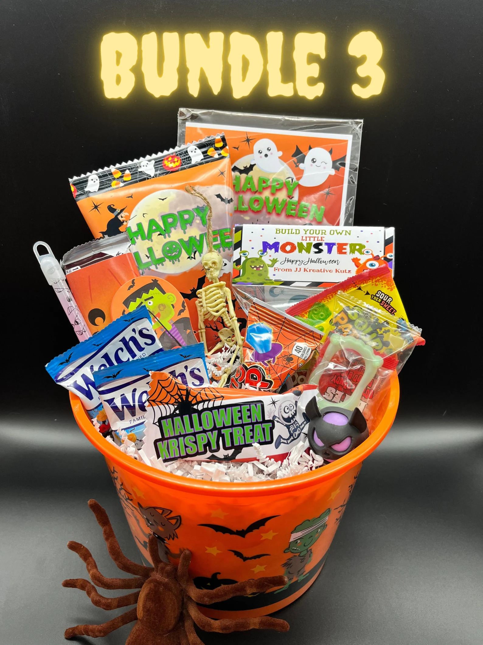 A customized orange Halloween bucket filled with candy, treats and spooky toys, one of the best Halloween boo basket ideas for kids.