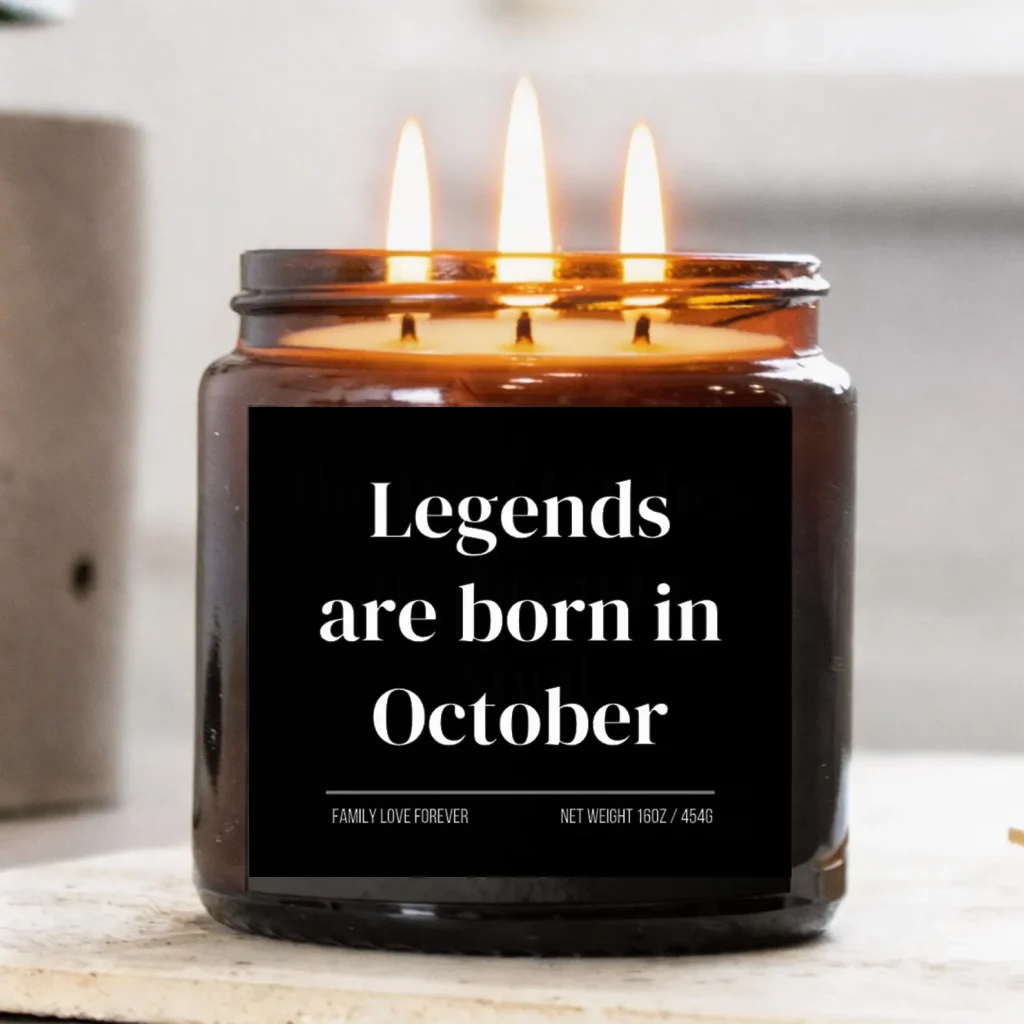 A triple wick amber jar candle with a bold black label glowing warmly, a fun and celebratory October birthday gift idea.