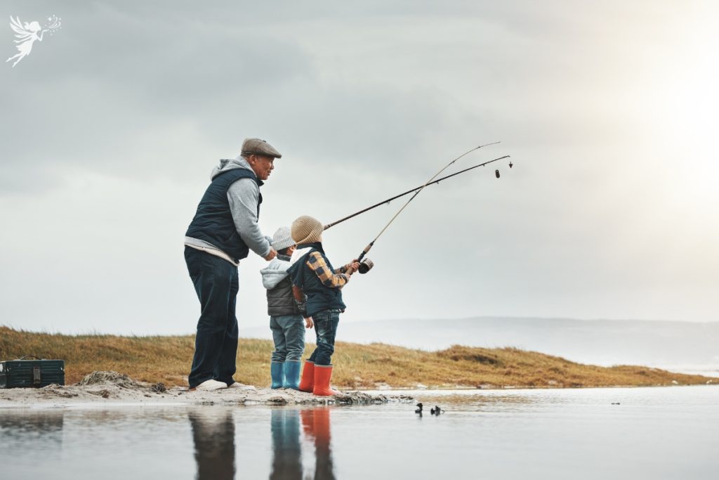 grandad showing his two grandsons how to fish
