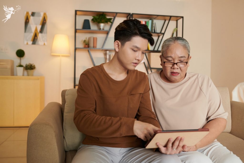 teenage grandson showing his grandma how to use electronic device