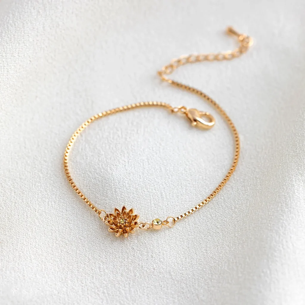 A dainty gold box chain bracelet with a detailed chrysanthemum birth flower charm and small citrine accent bead, a sweet November birthday gift idea.