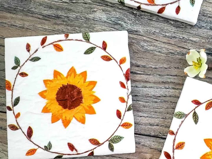 Floral sunflower decoupage coasters arranged on a rustic wooden surface, beautiful and practical homemade gifts for grandparents.