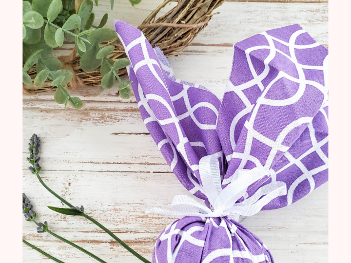 A purple patterned fabric bunny-shaped lavender sachet tied with ribbon, a fragrant and adorable homemade gift for grandparents.
