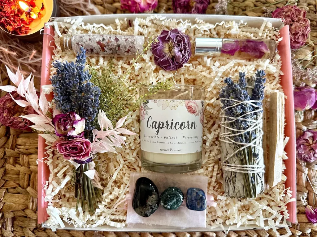 A Capricorn gift box with a zodiac candle, crystals, sage, dried flowers and roller oil, a thoughtful and luxurious January birthday gift idea.