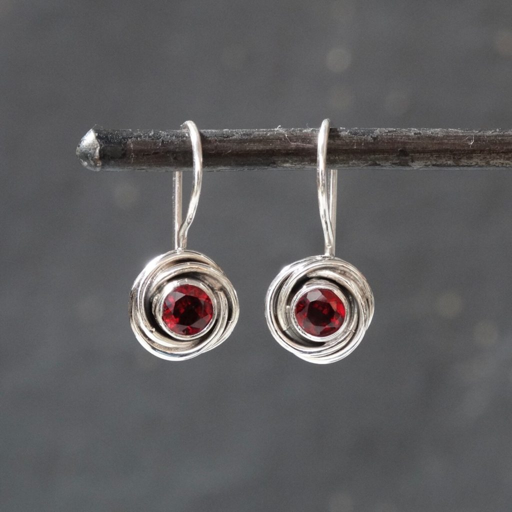 Silver swirl drop earrings with deep red garnet birthstones, a beautiful and classic January birthday gift idea.