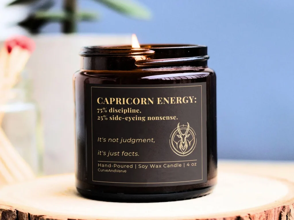 A funny Capricorn Energy hand poured soy wax candle in an amber jar, a witty and on brand January birthday gift idea.
