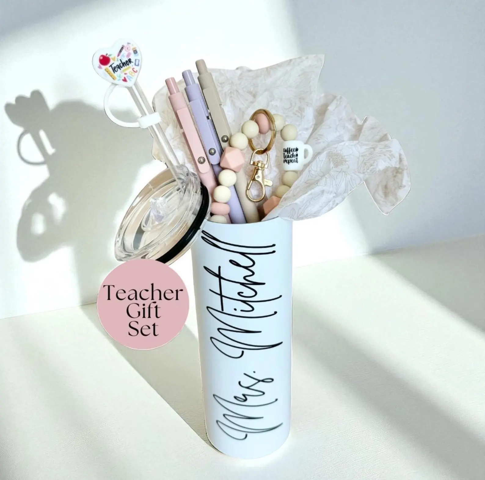 Personalized white tumbler filled with pastel pens, beaded keychain and teacher charm topper, a practical and stylish teacher appreciation gift ideas set any educator would treasure.