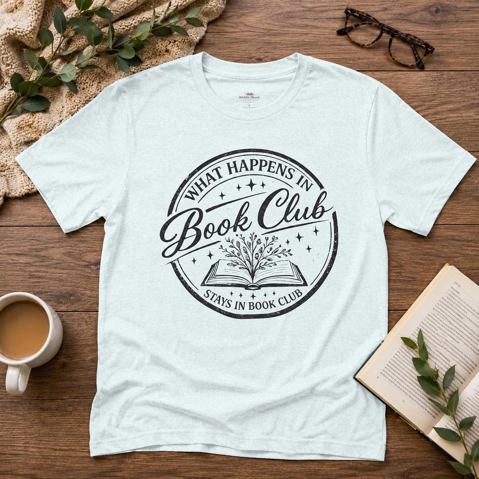 Light blue What Happens in Book Club Stays in Book Club vintage stamp graphic tee styled with coffee and an open book, a must have book club squad gifts members will wear with pride.