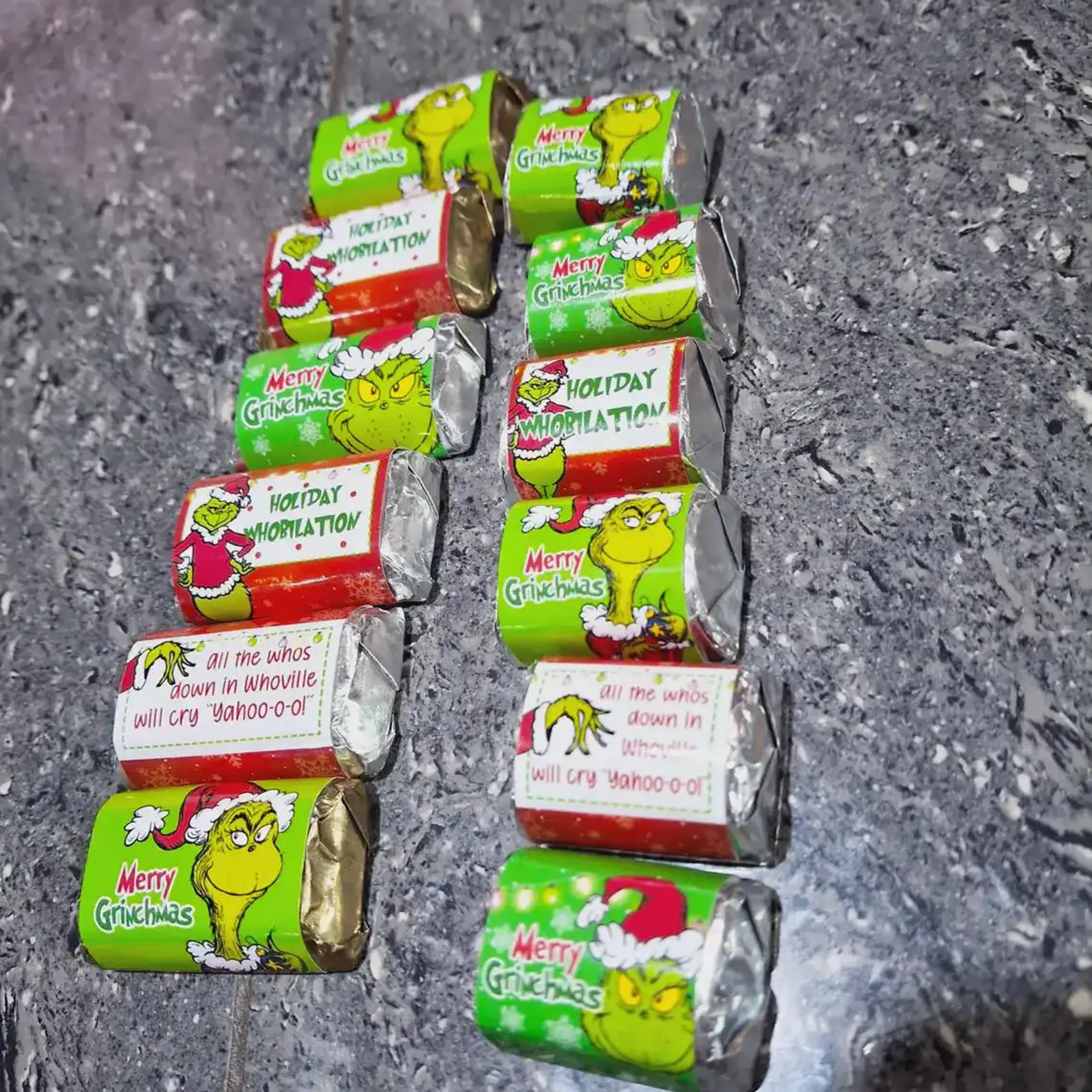 Mini chocolate bars wrapped in Merry Grinchmas and Holiday Whobilation green and red Grinch labels, adorable and easy Grinch party sweet treat favors guests will devour.